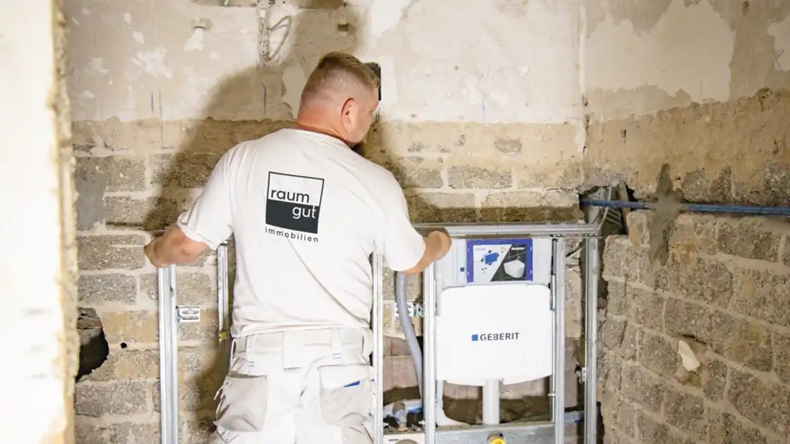 Ein Mitarbeiter vor einer unverputzten Wand