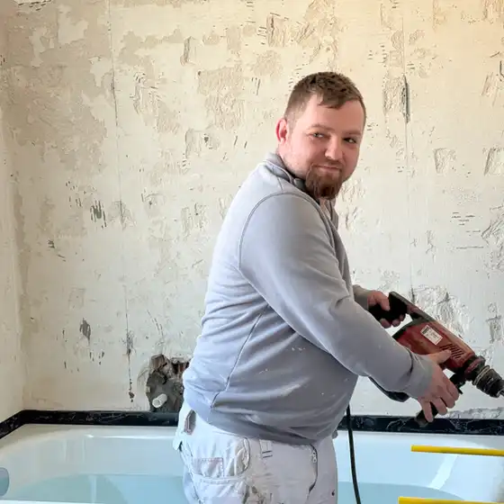Ein Handwerker auf einer Badezimmer-Baustelle