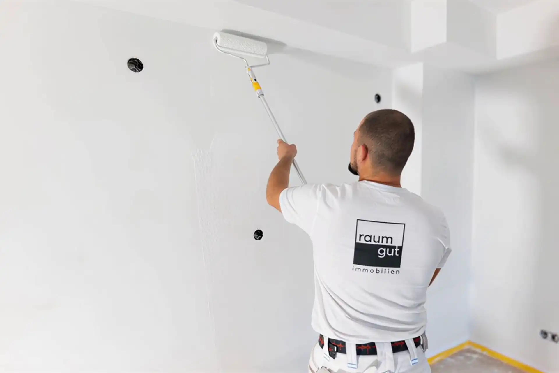 Ein Maler von raumgut streicht eine Wand