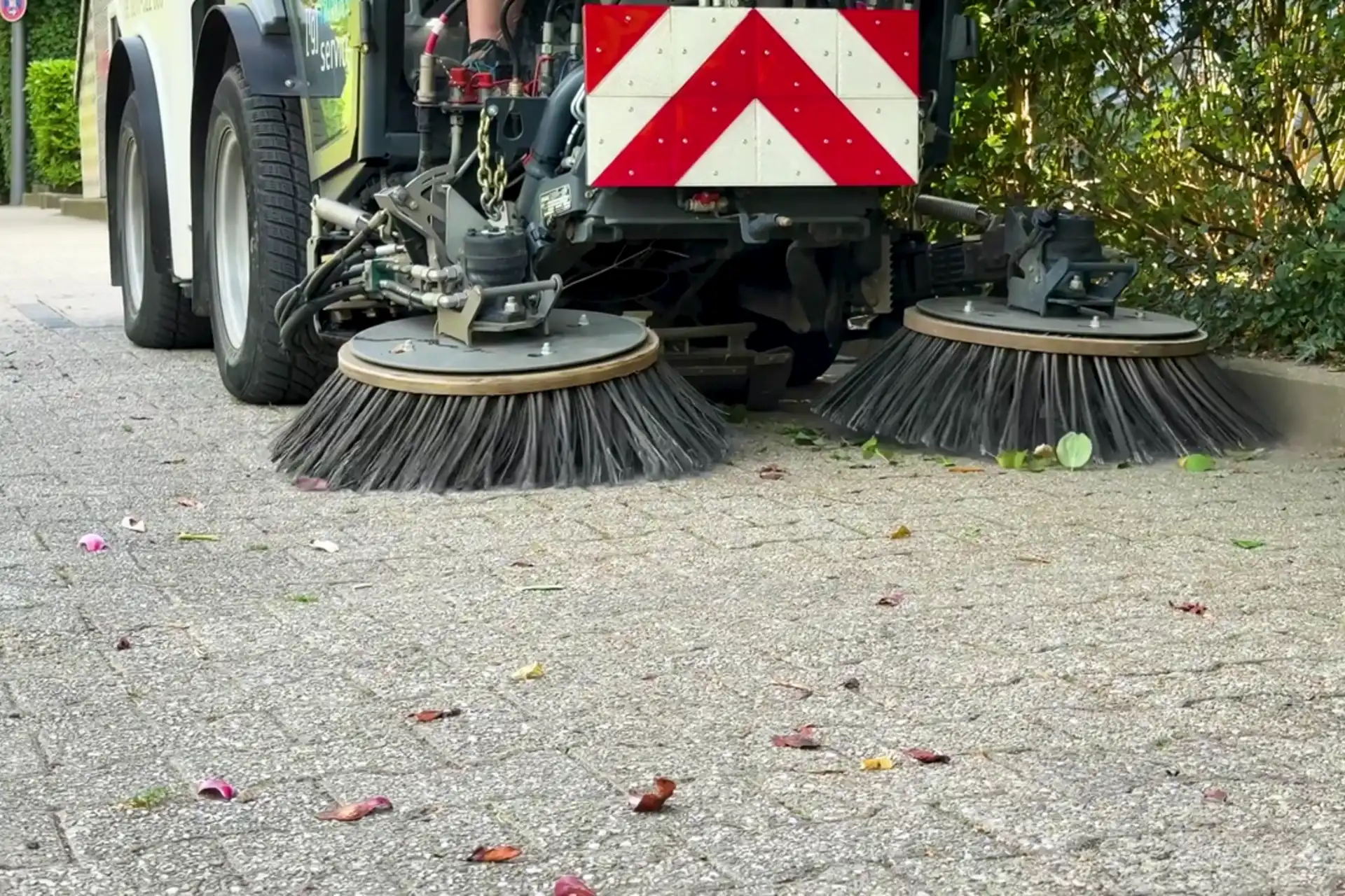 Bürsten einer Kehrmaschine auf einem Gehweg