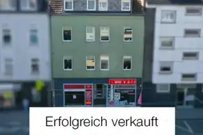 Mehrfamilienhaus mit Schriftzug "Erfolgreich verkauft"